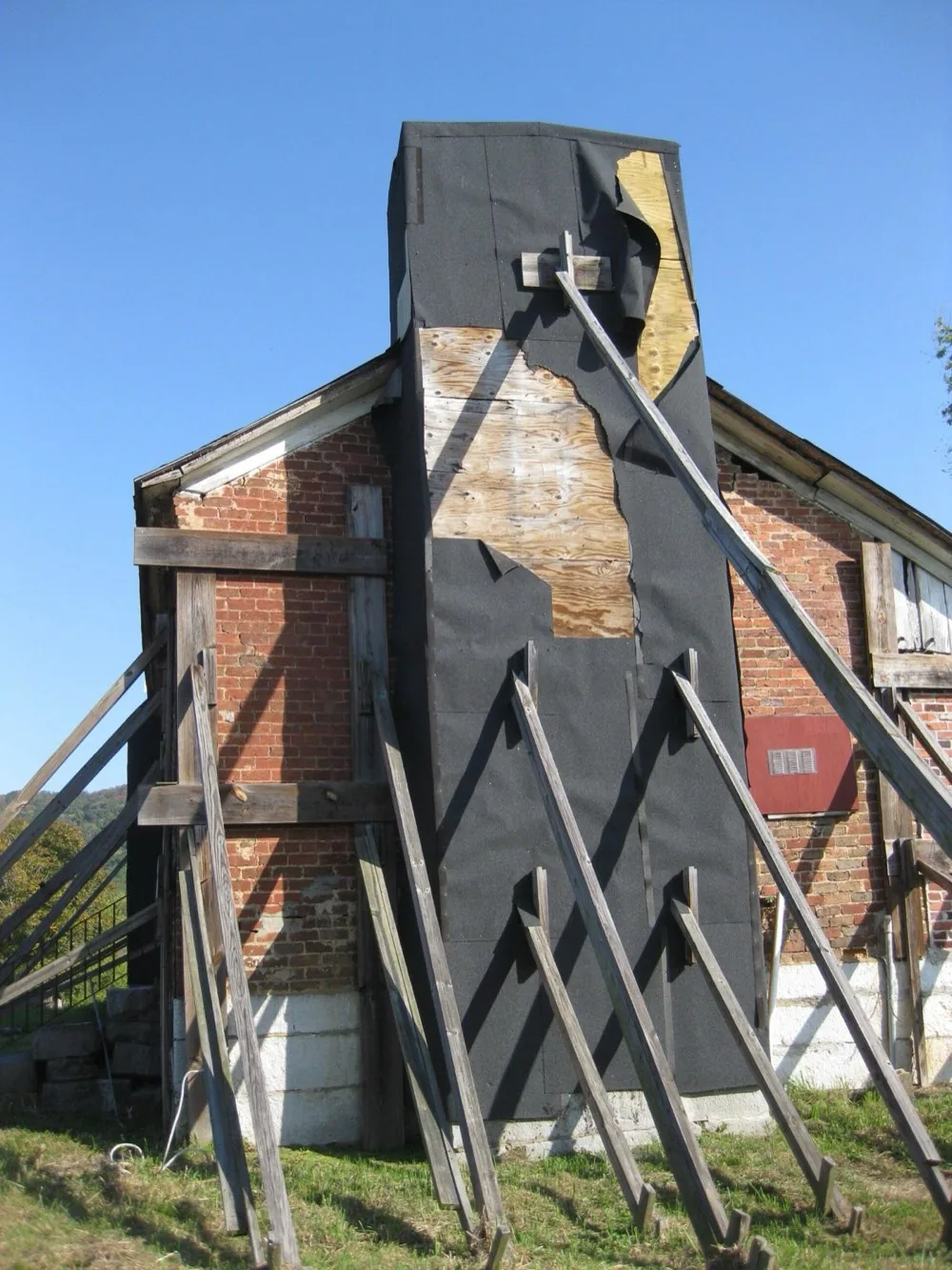 Chimney chase braced and wrapped during structural repair