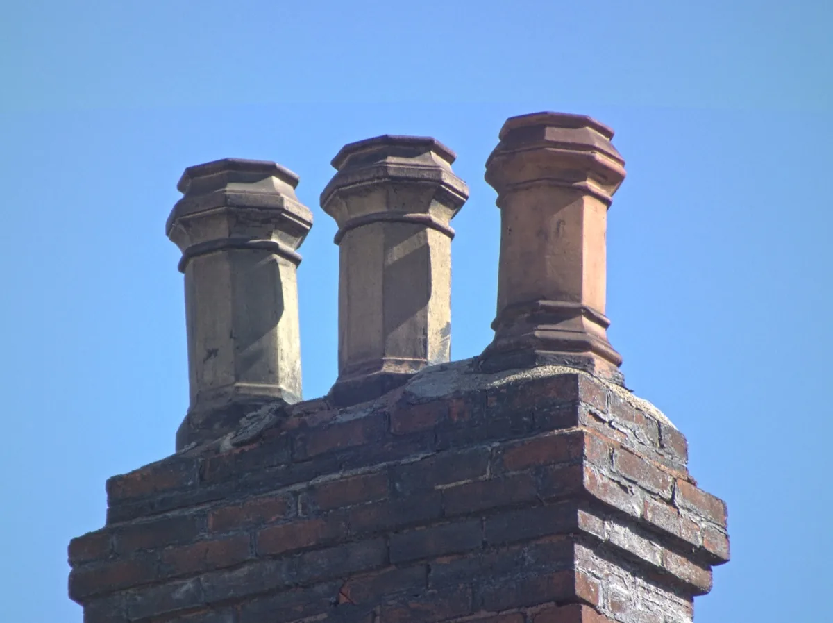 Clay chimney pots on an aging brick crown